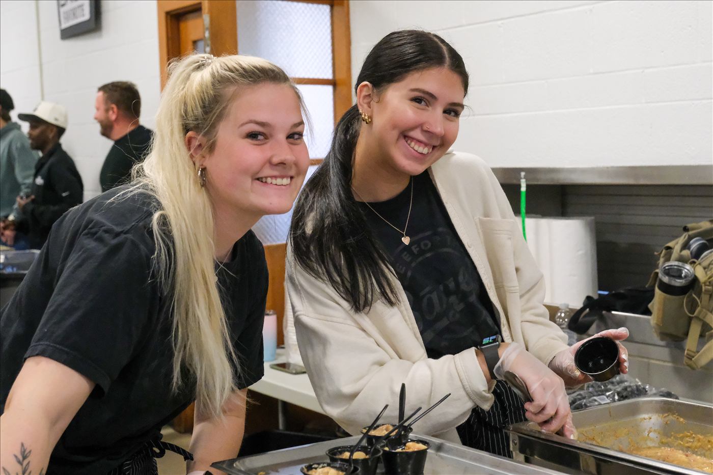Two team members smiling in the kitchen