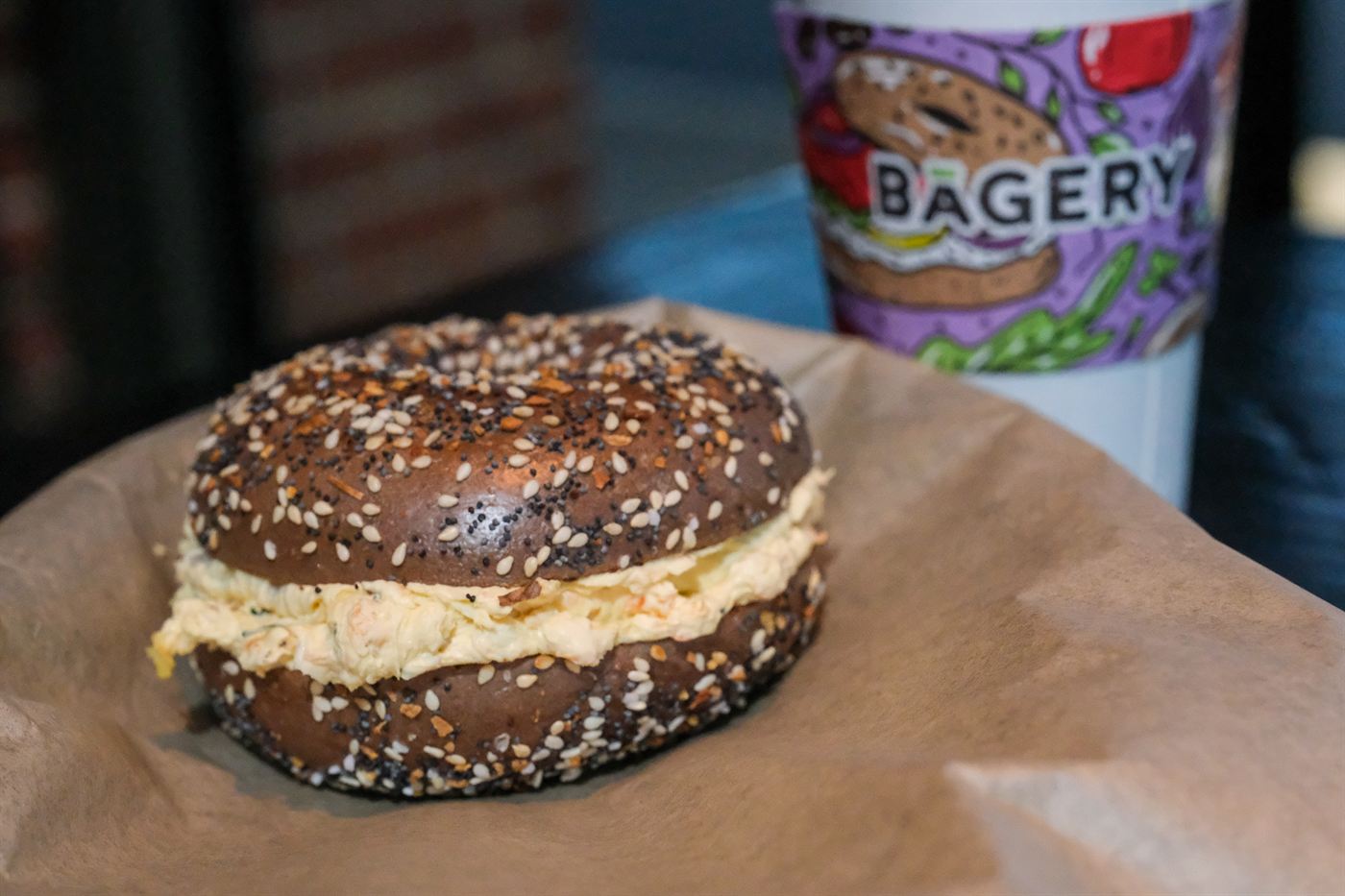 Bagel with cream cheese and a branded coffee cup